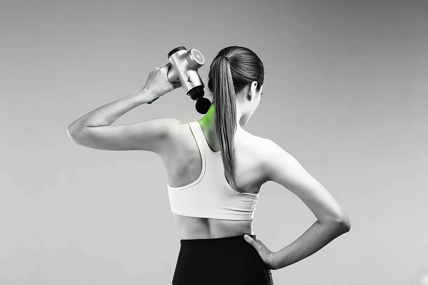 Woman using a massage gun on her neck
