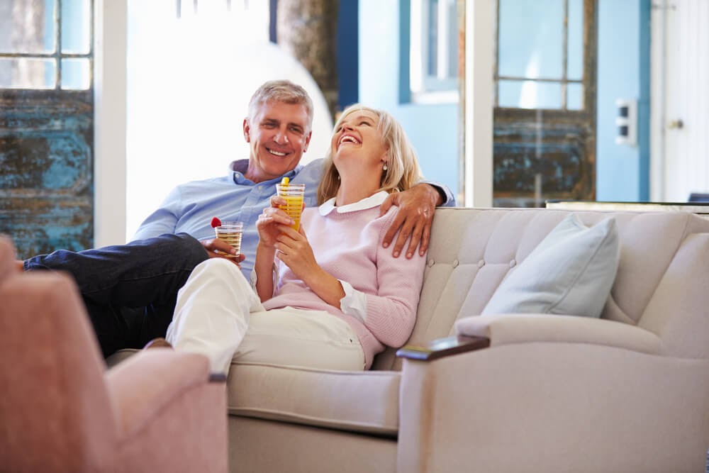 Couple enjoying retirement, cuddled on their couch
