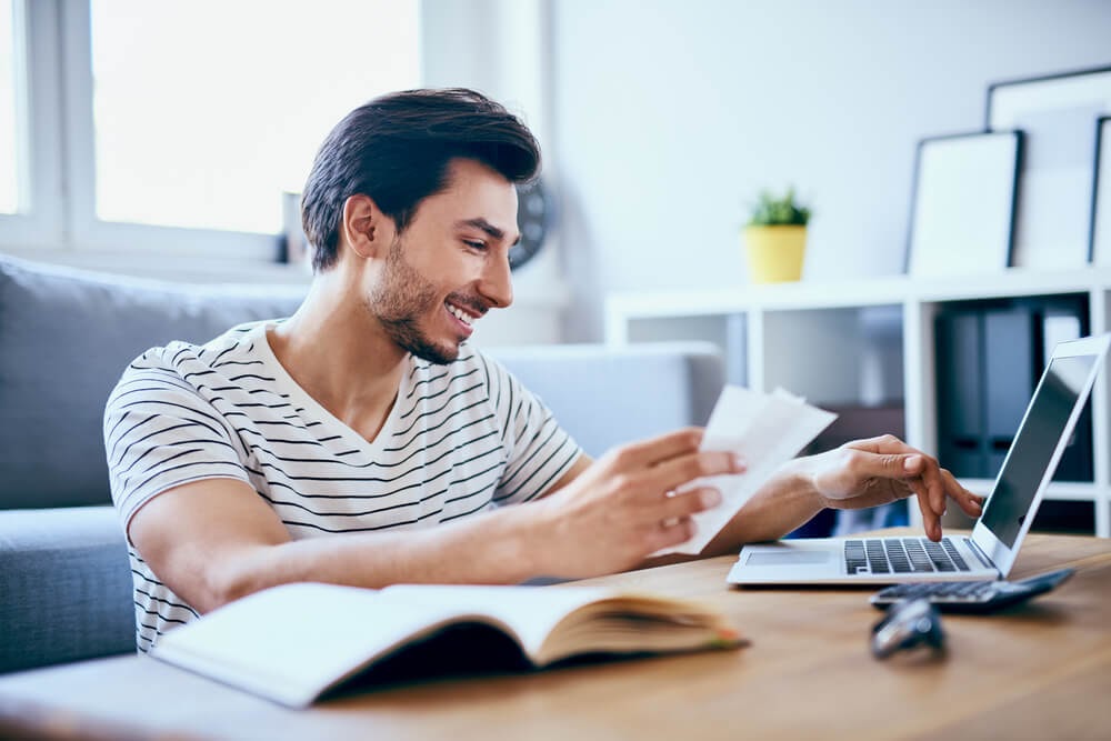 Man working on his laptop from his coffee table
