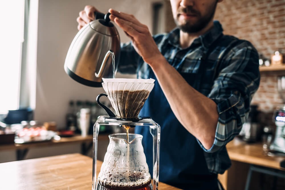 Man brewing pour over mushroom coffee.