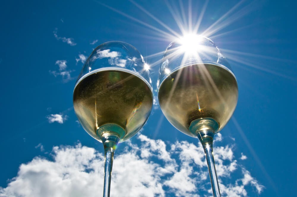 Two glasses of white wine glowing in the sun