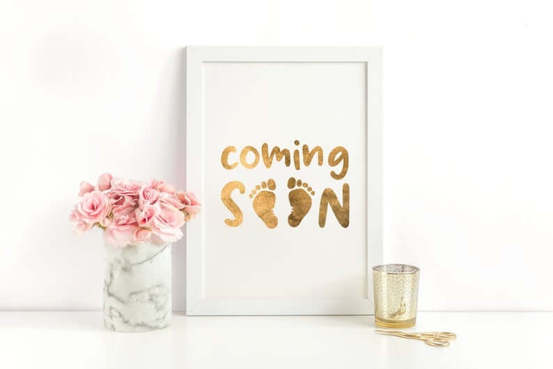 Picture saying "Coming Soon" with baby footprints