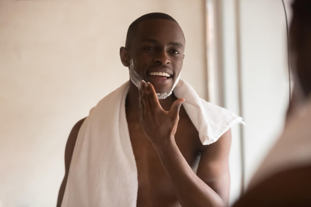 Man applying shave cream in the mirror