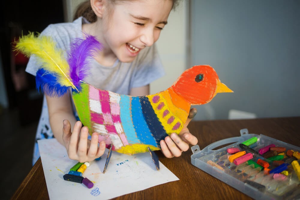 Girl enjoying a cardboard chicken she made