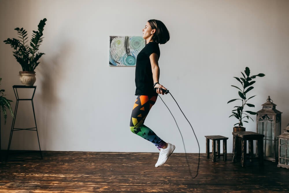 Woman jump roping in her living room