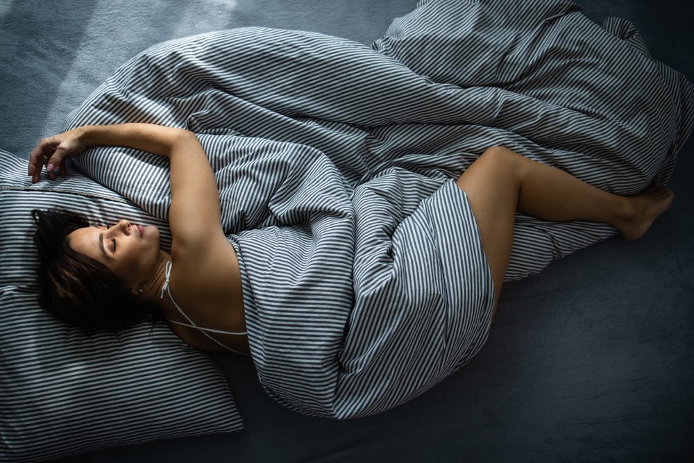 Woman curled up in her bed