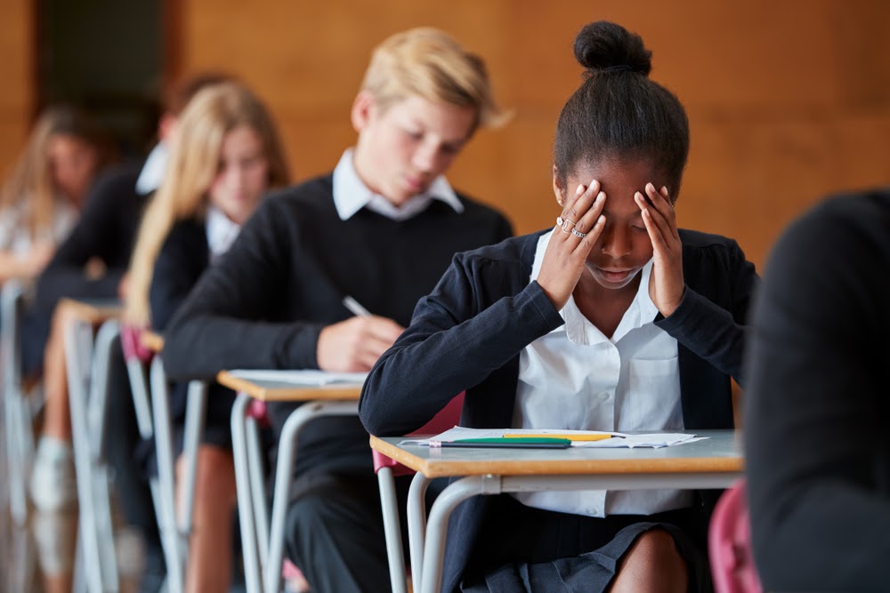 Girl struggling in school, holding her head in her hands