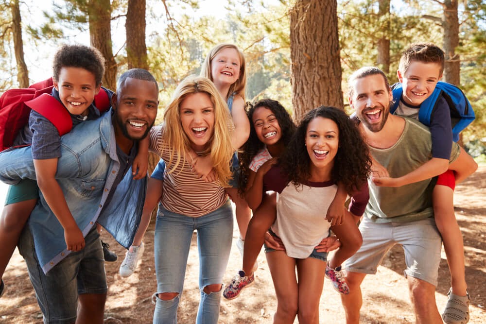 A group of friends and their children having fun while being in nature
