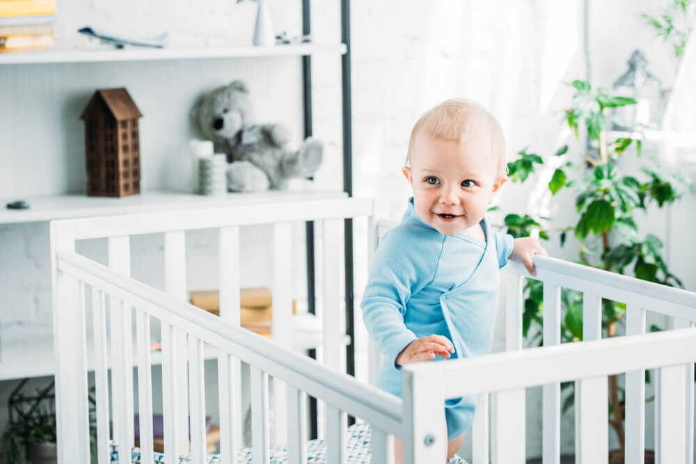 Baby boy standing in his crib