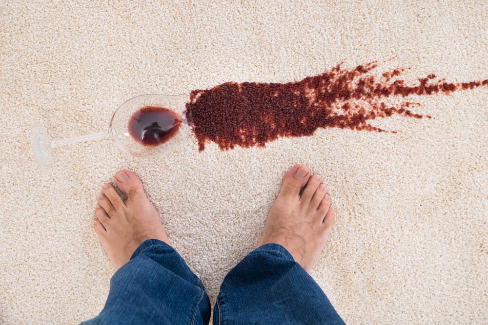 Glass of red wine, spilled on white carpet