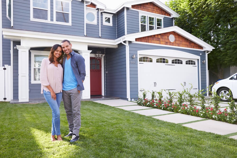 Couple in front of their house