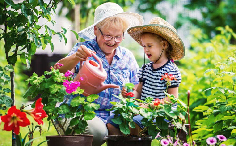 grandma and grand daughter watering plants with watering can