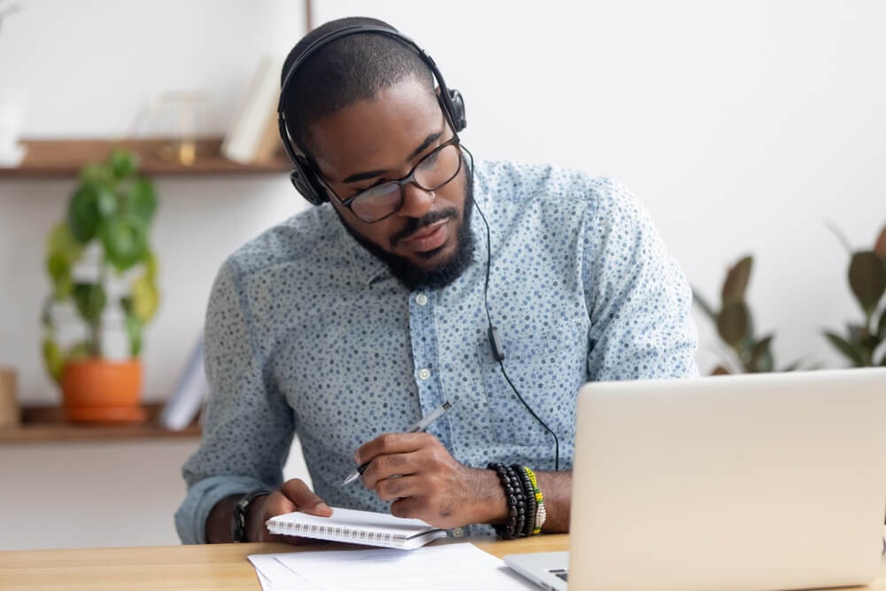 Man looking at his laptop with headphones on