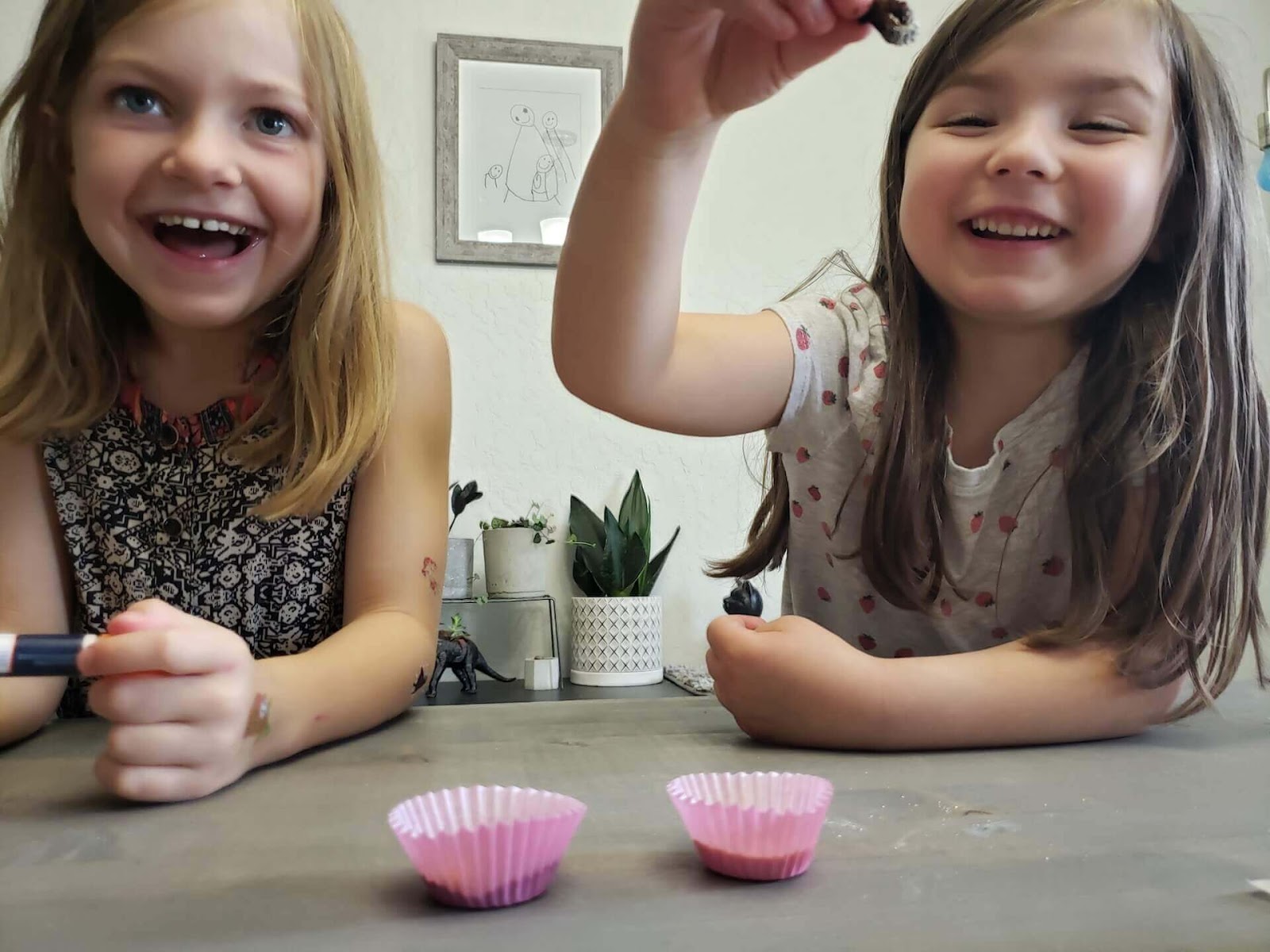 Girls holding up broken pipecleaner bee
