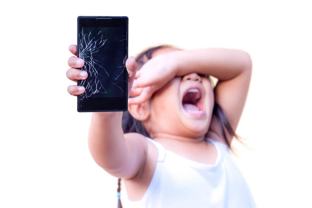 Girl holding a cracked smartphone