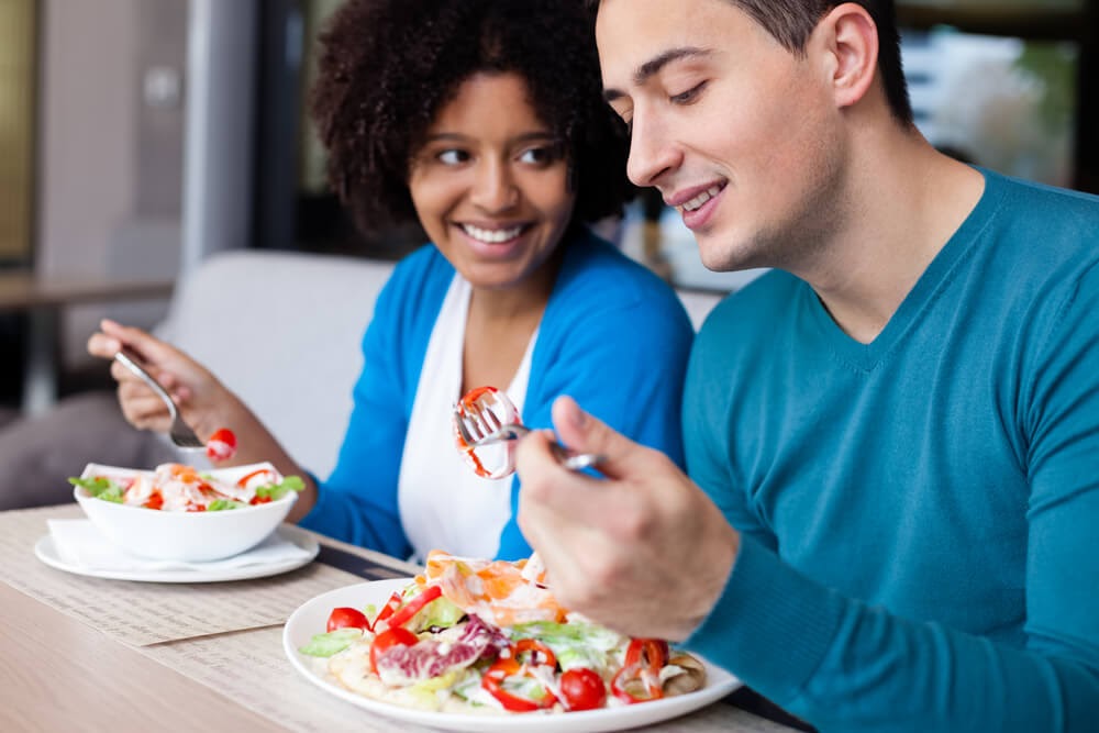Young couple eating salads together