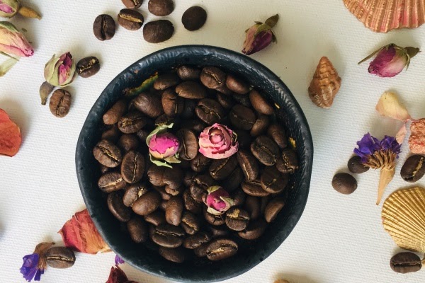Flowers on top of a bowl of coffee beans