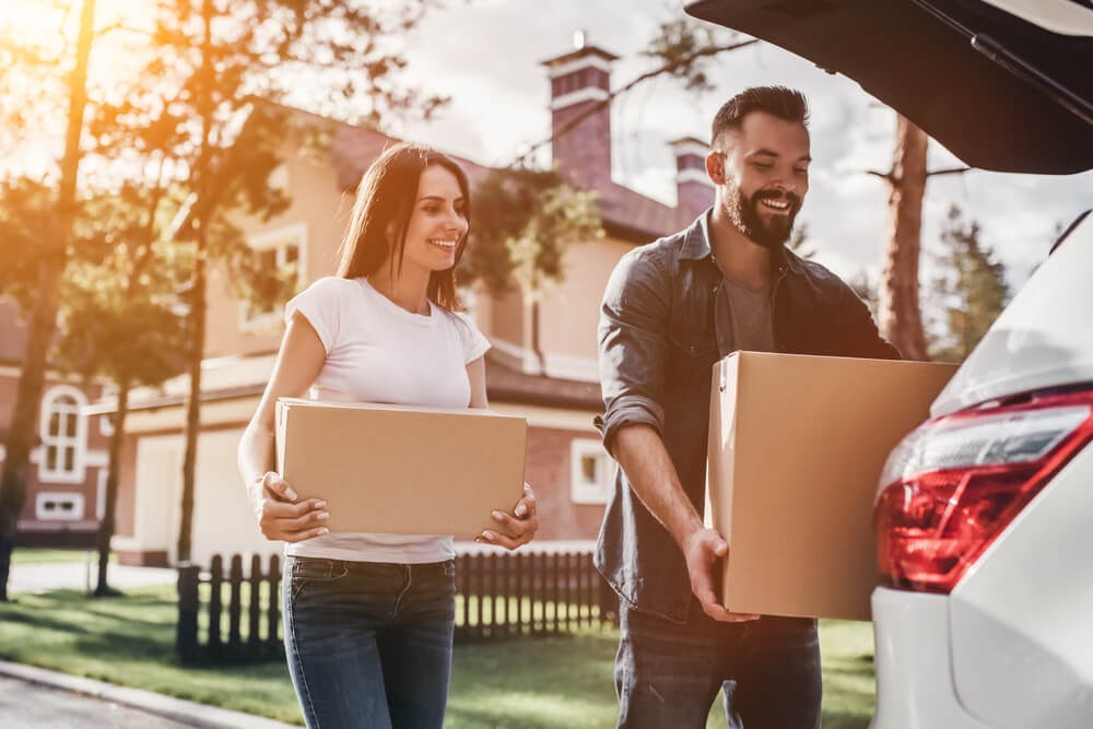 Man and woman putting boxes in a car