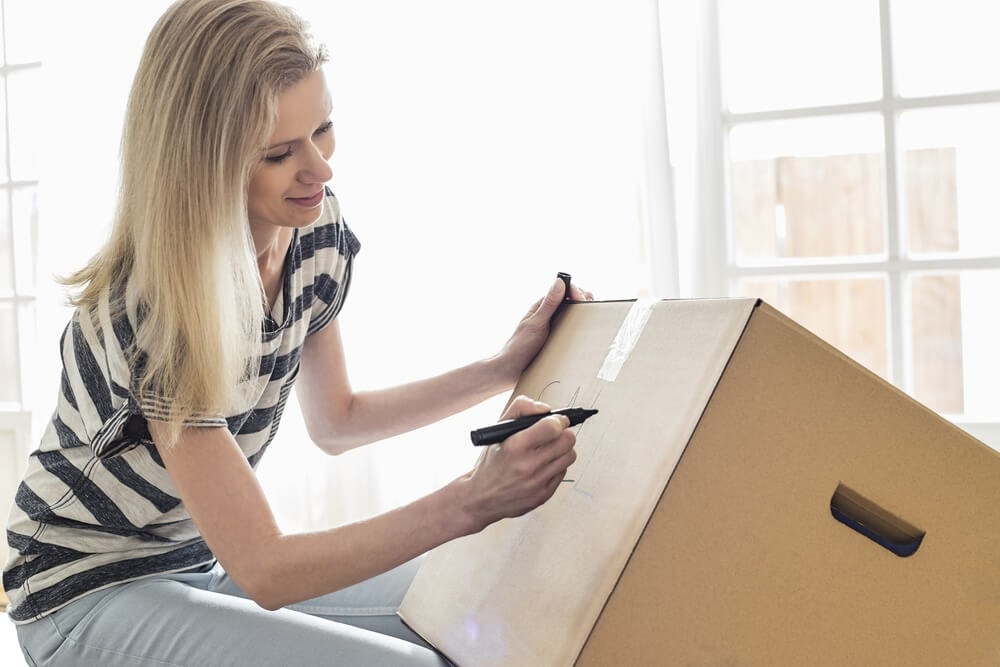 Woman writing on a moving box