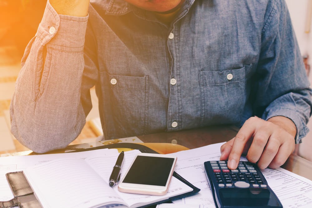 Man looking over his finances with his calculator