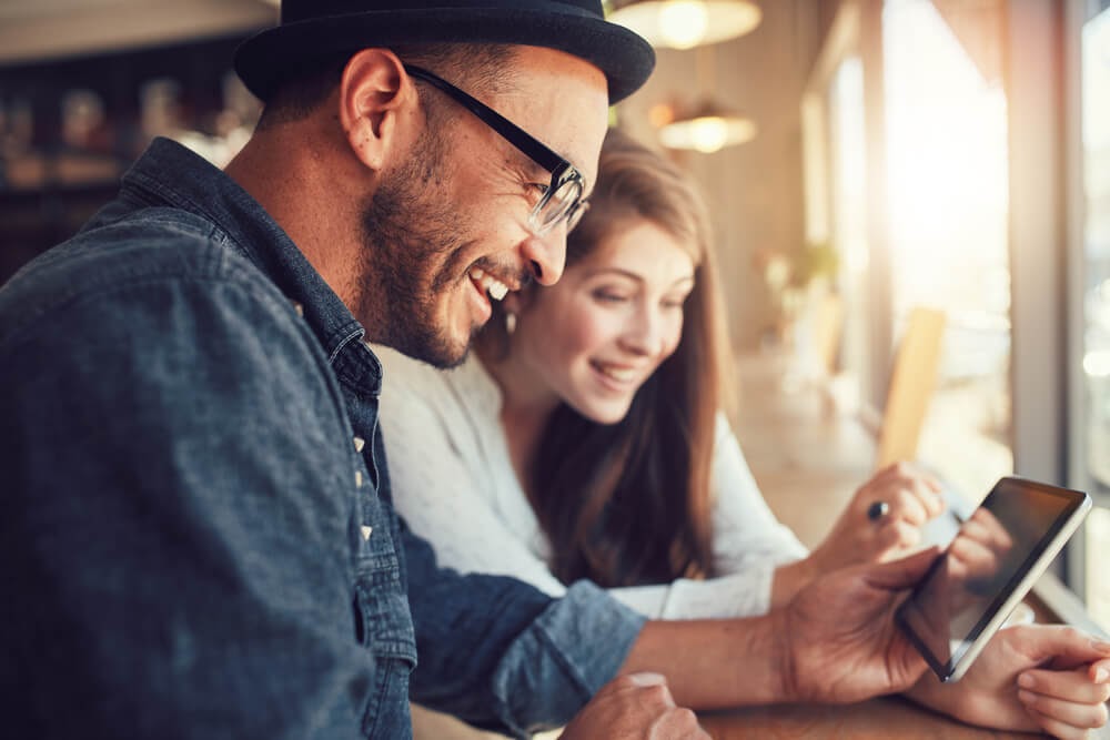 young man and woman looking at tablet