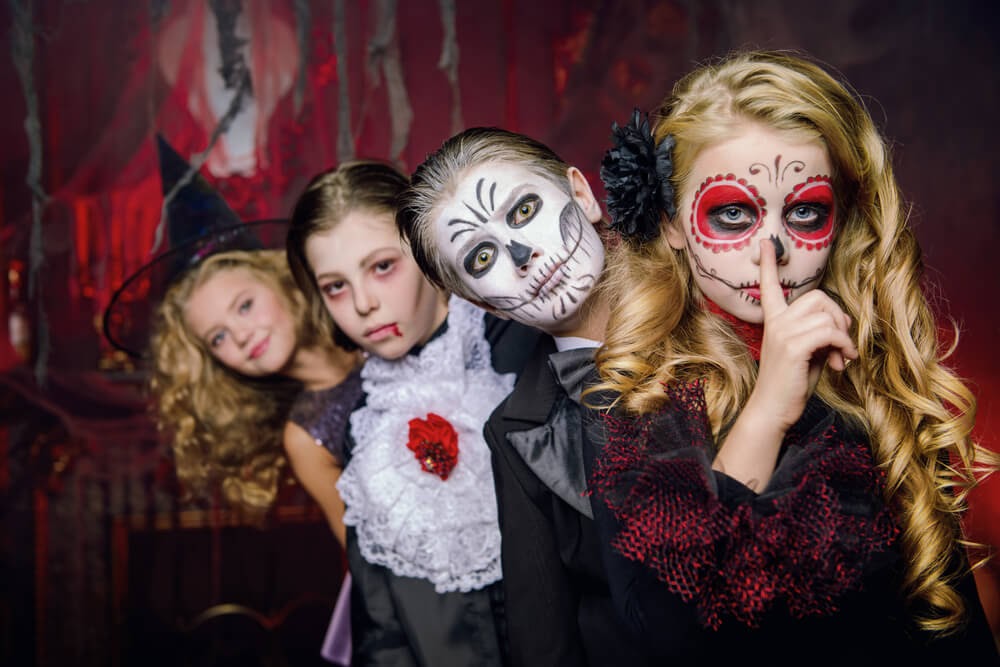 Children in halloween costumes looking at the camera