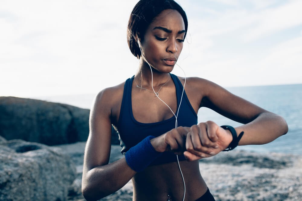 Woman looking at her watch on the beach