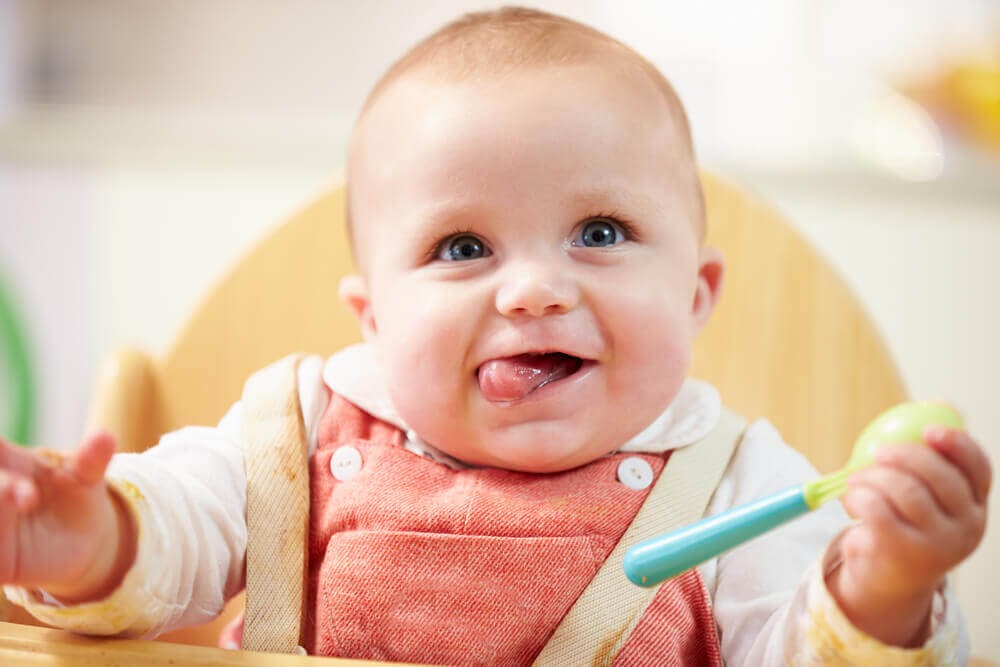 Baby smiling at the camera from his high chair