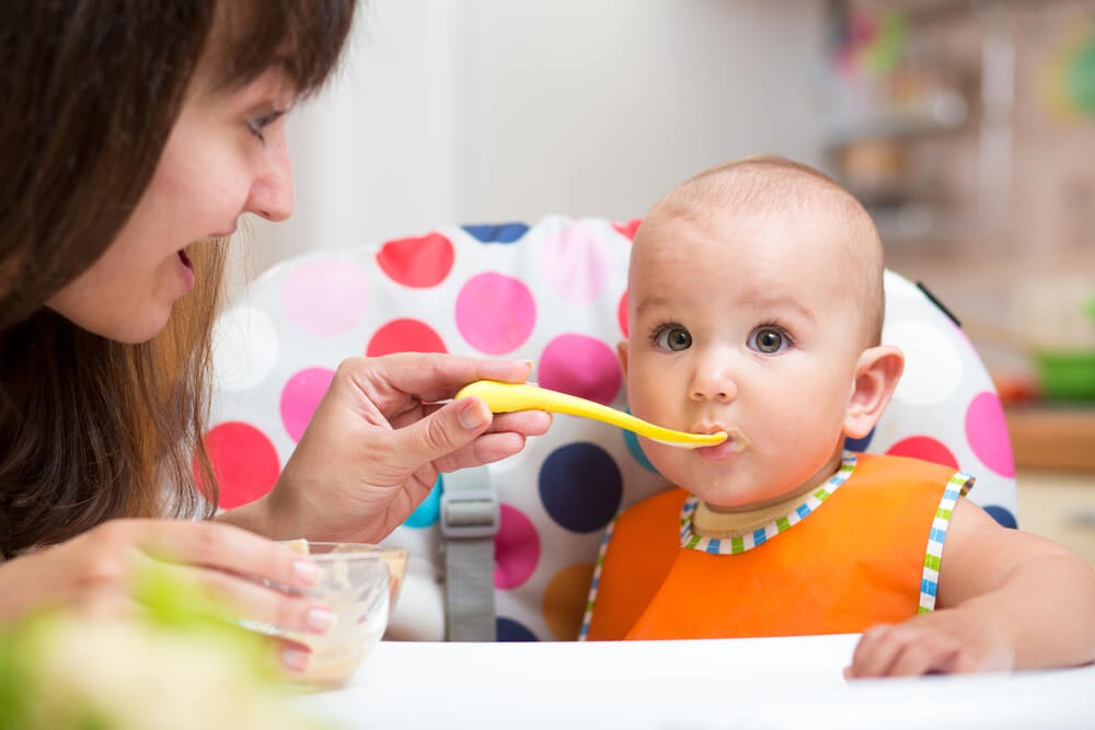 Mom feeding green eyed baby girl