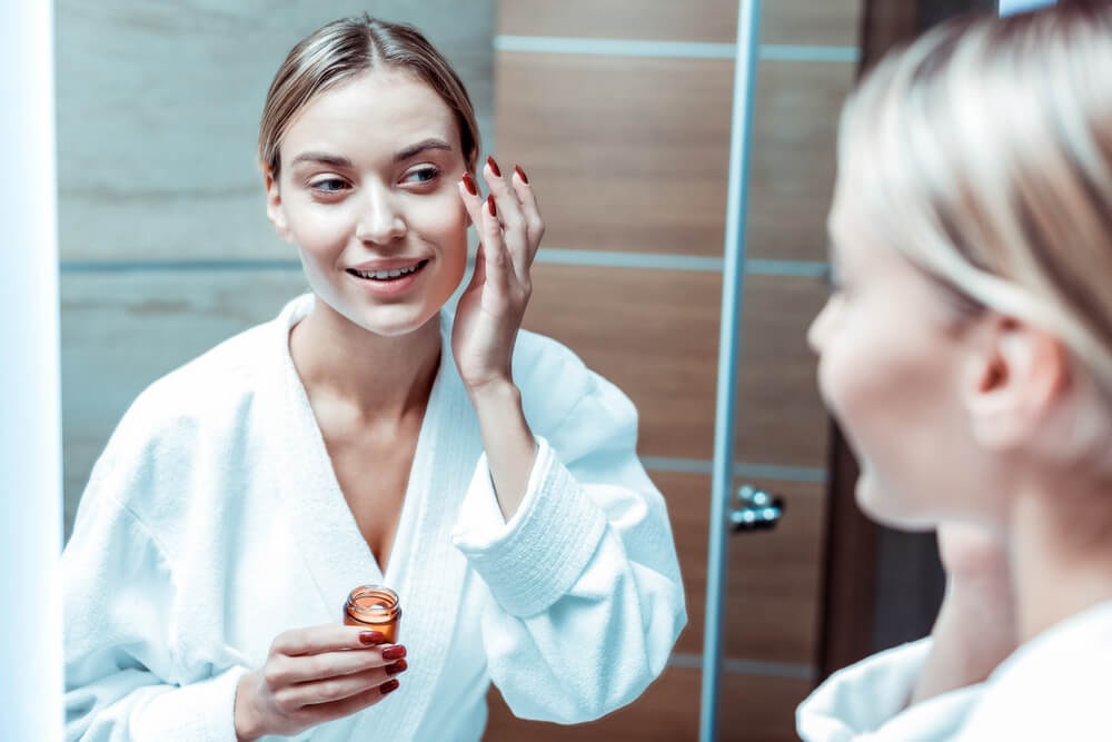 Woman looking at her face in the mirror