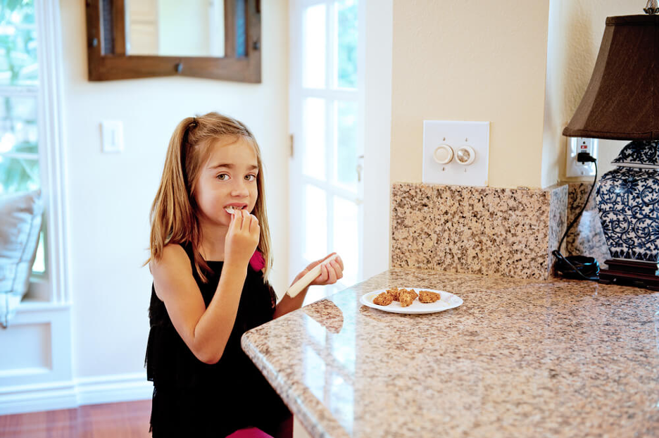 Girl eating some snacks at the kitchen counter