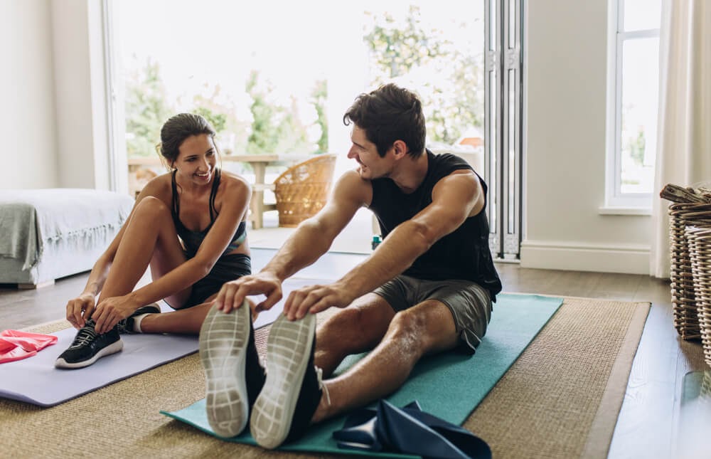 Man and woman stretching on their yoga mats