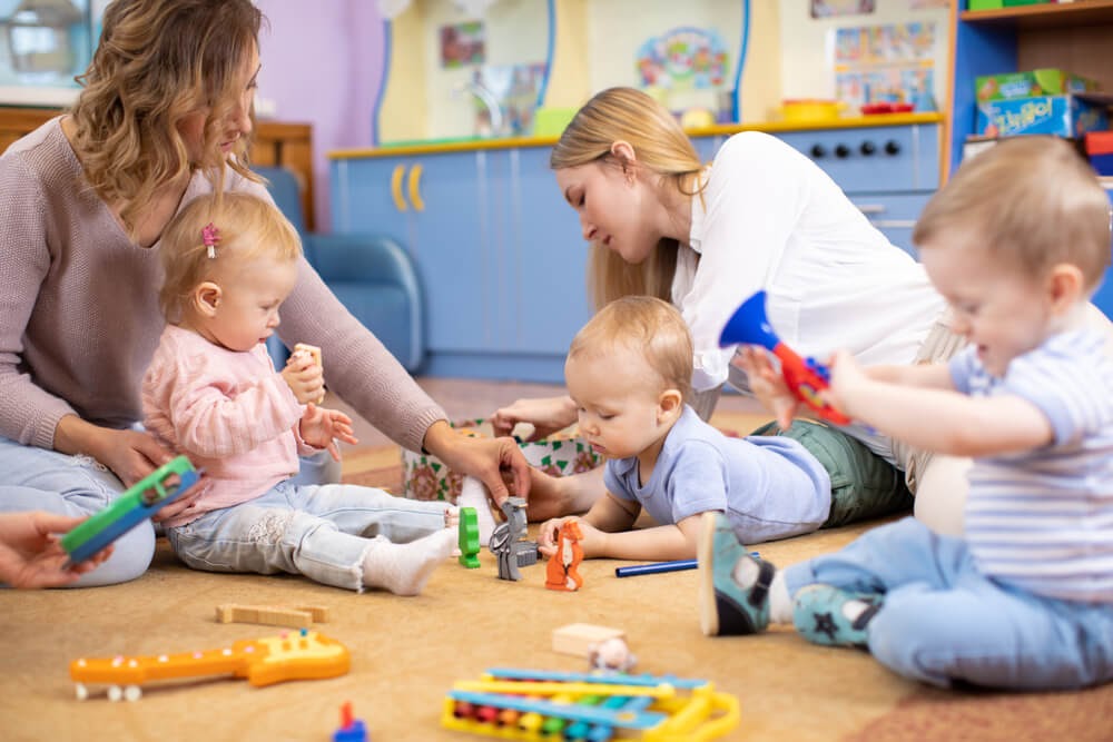 Two ladies playing with toddlers