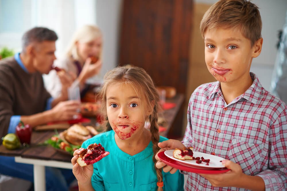 Kids enjoying thanksgiving meal with messy faces