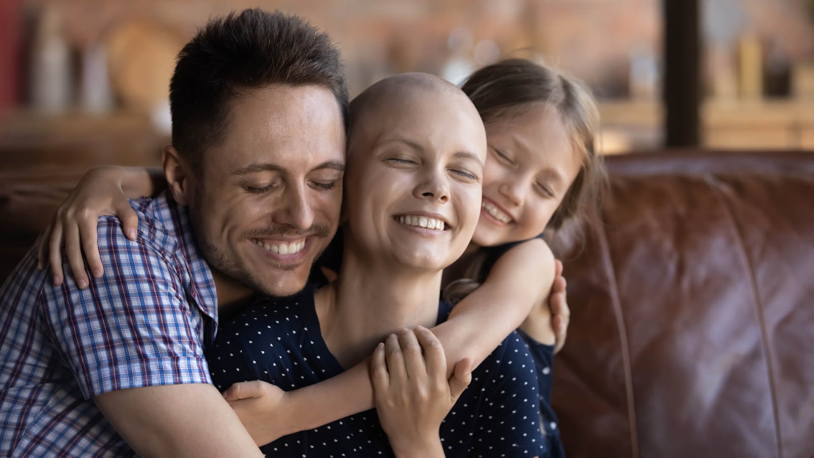 Dad and daughter hugging cancer-ridden wife