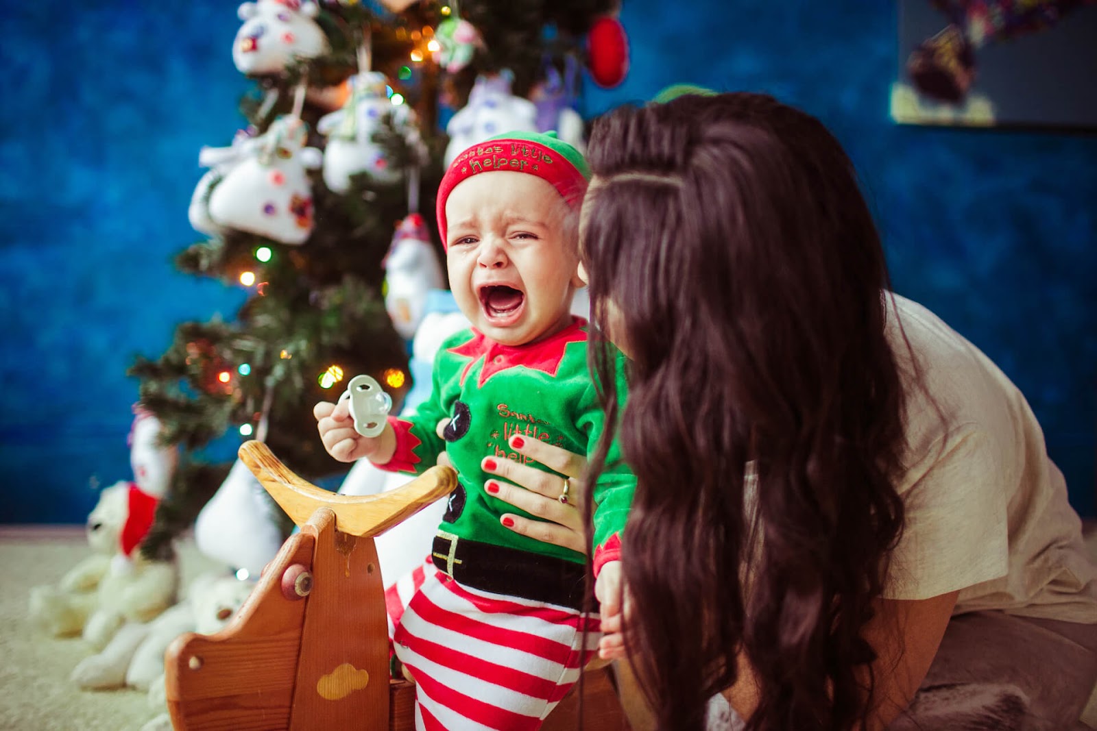 Baby crying in front of Christmas tree