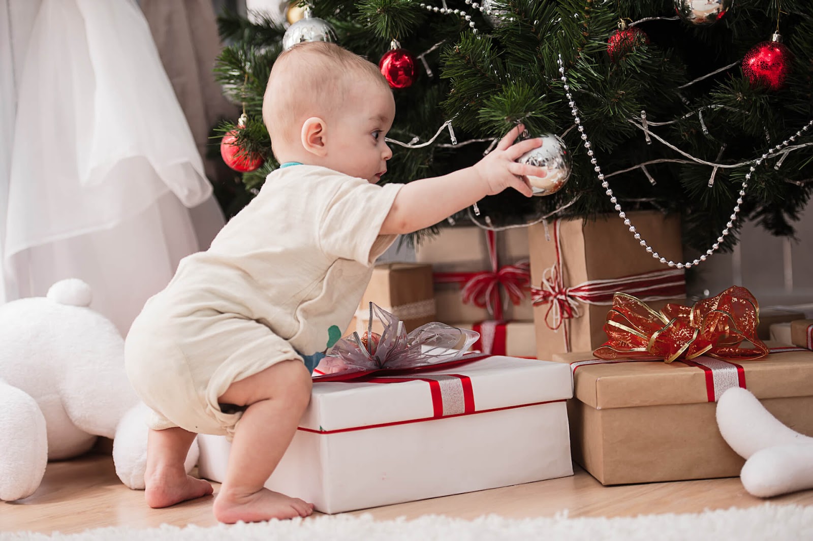 Baby playing with ornament on Christmas tree
