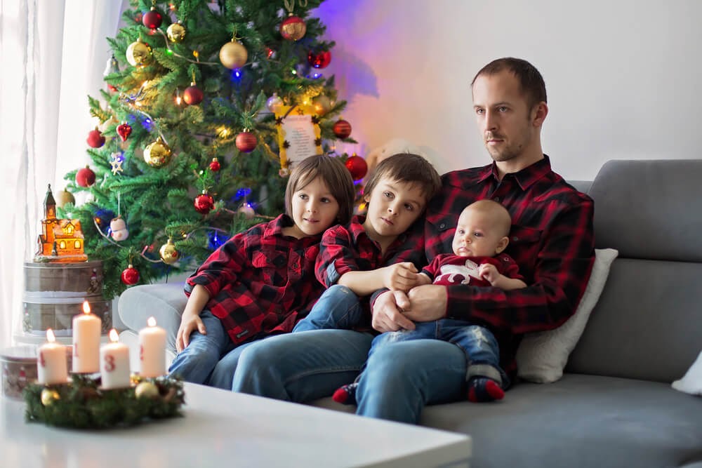Family watching a Christmas movie in matching flannel shirts