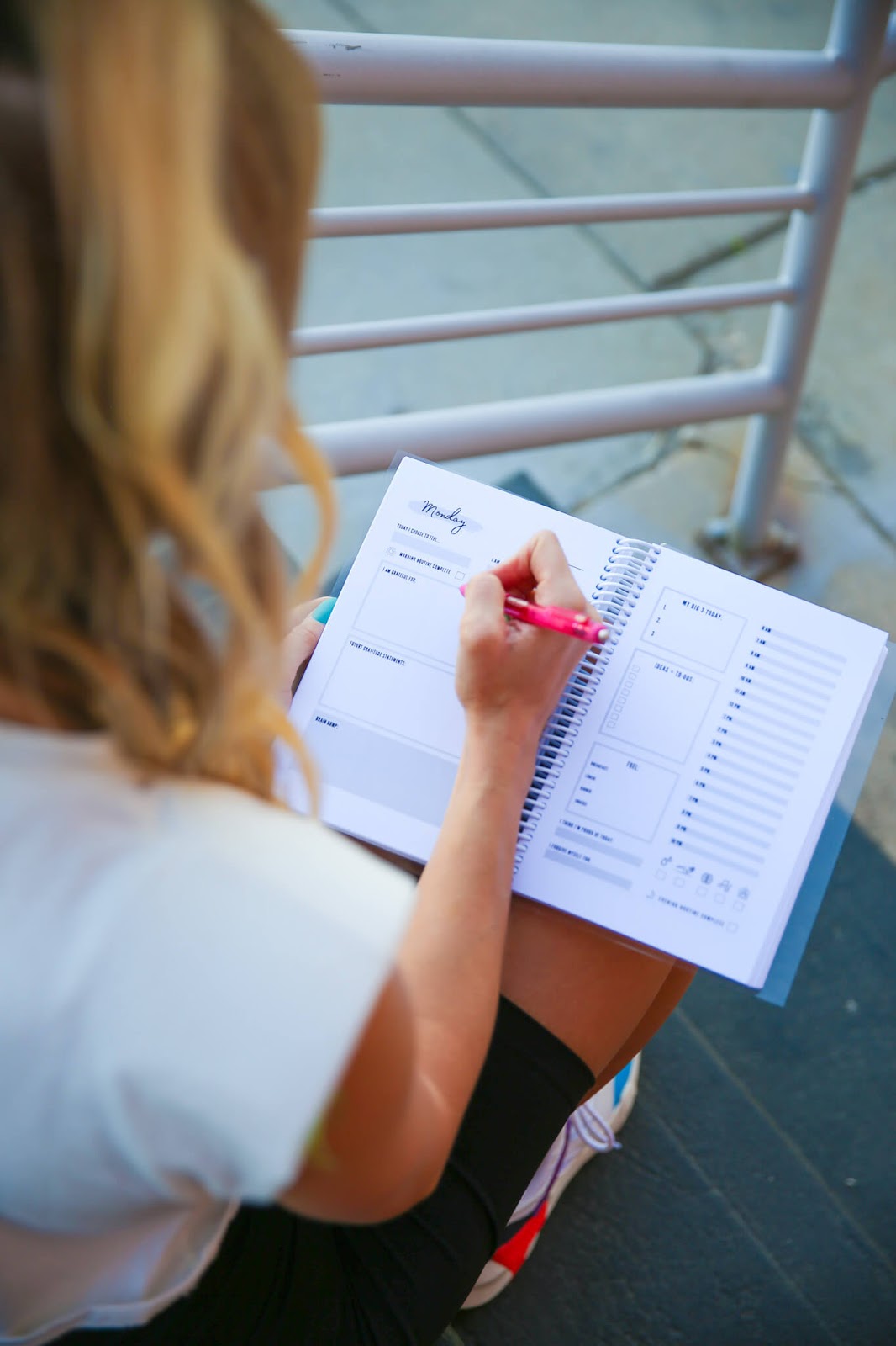 Person writing in a journal on a staircase