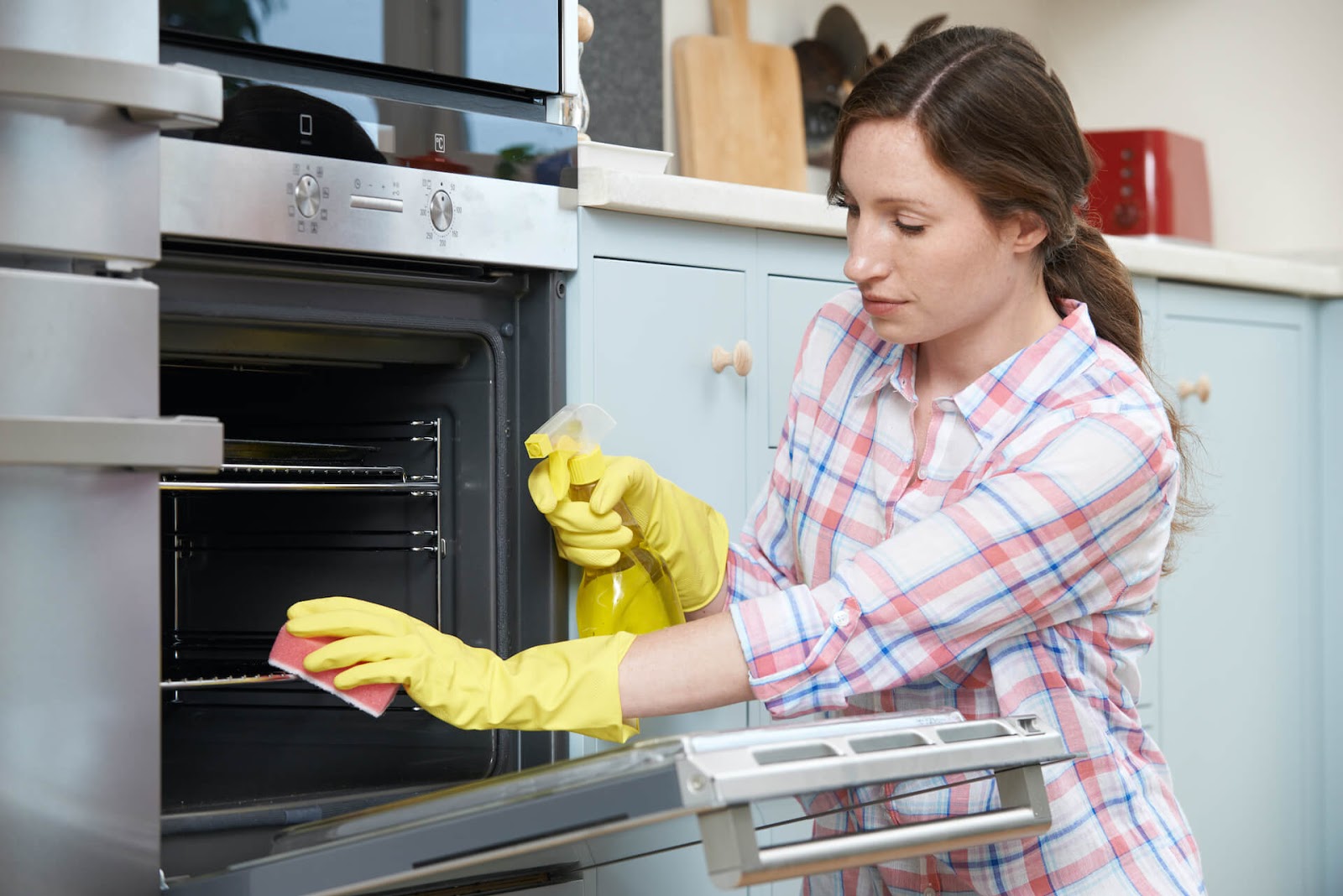 woman scrubbing her oven