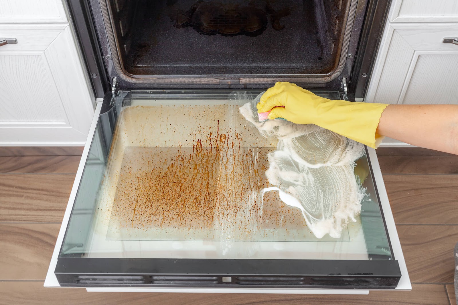 Woman cleaning her oven glass