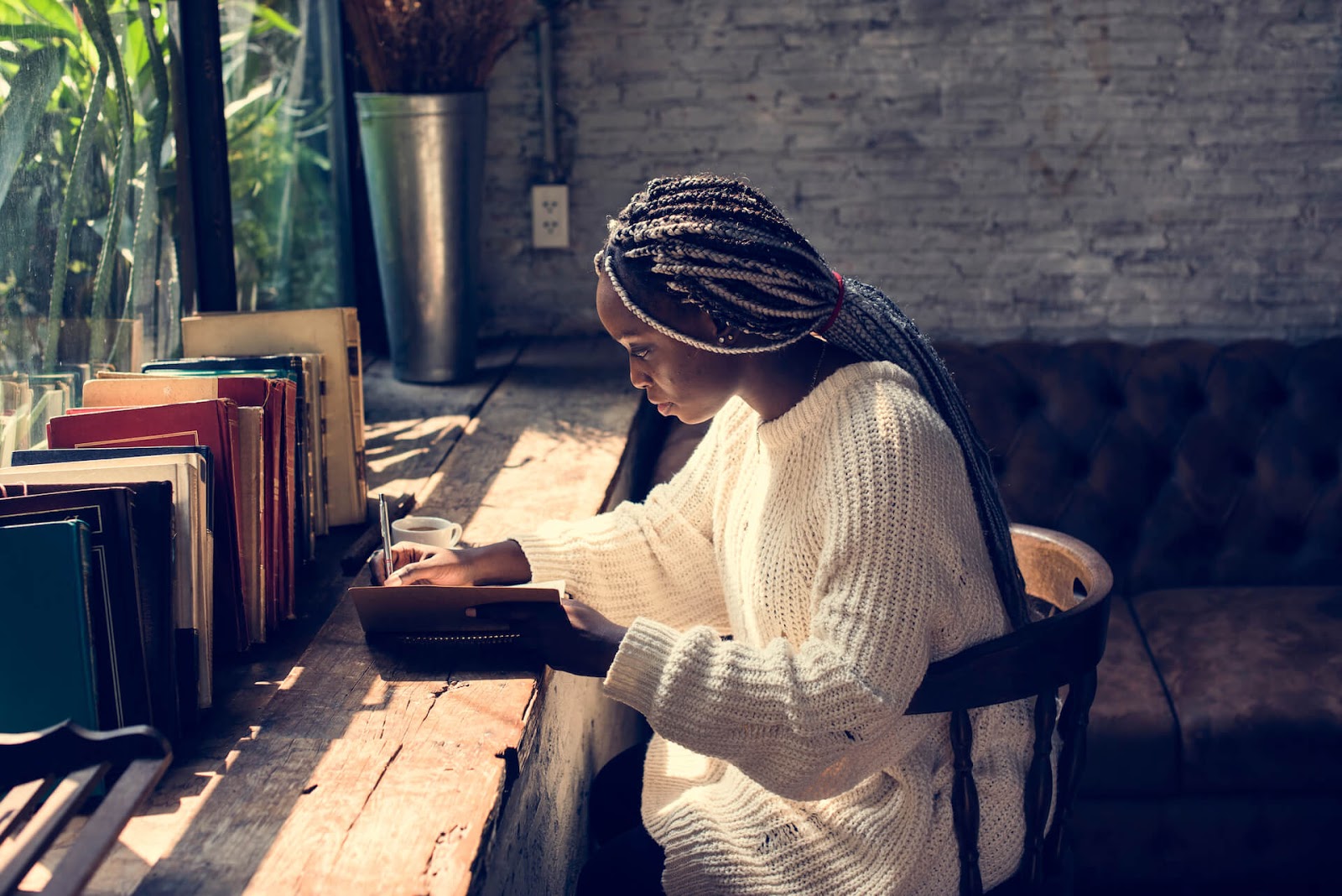 Woman writing in journal at a large desk