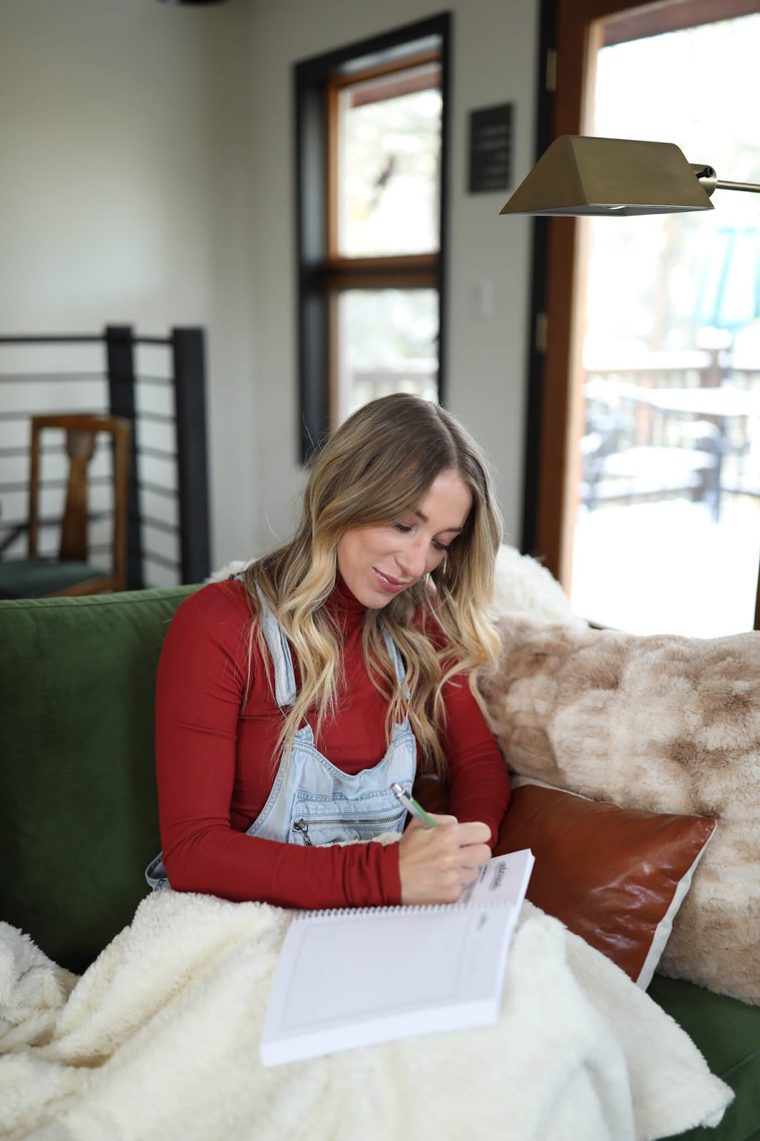 Woman writing in a journal on the couch