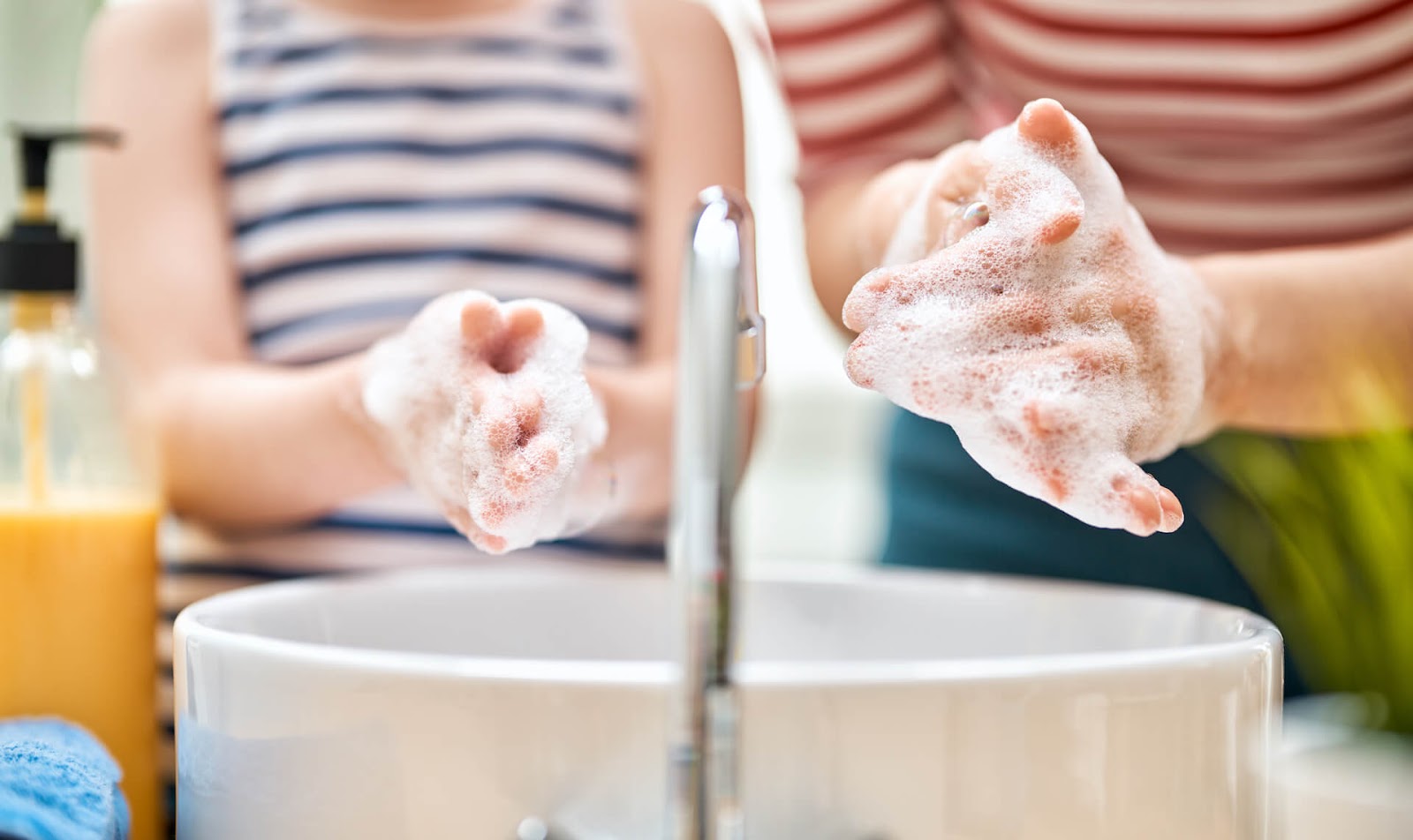Mom and child washing hands in the bathroom sink