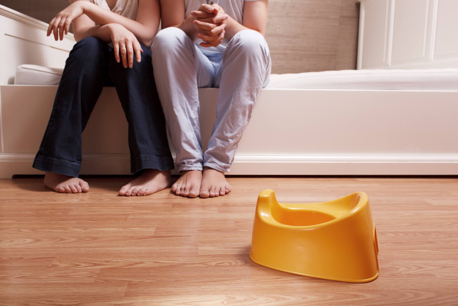 Parents sitting on their toddler bed discussing something
