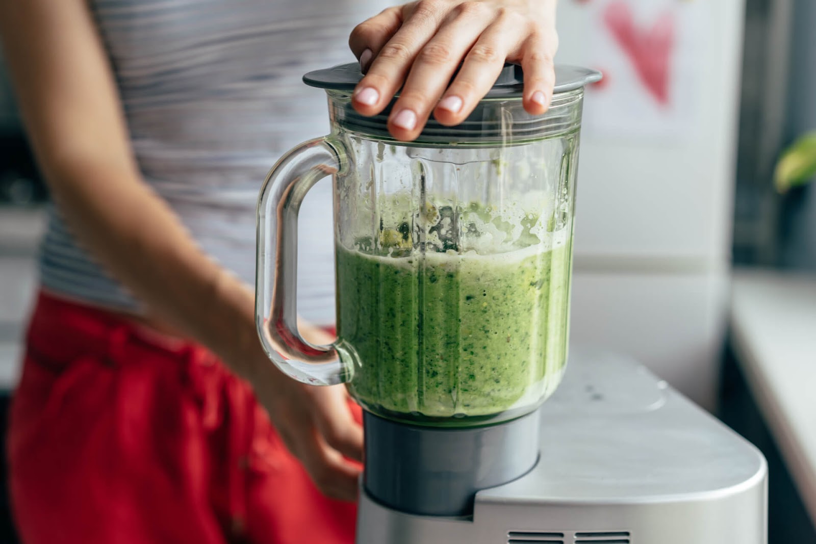 Person preparing green smoothie