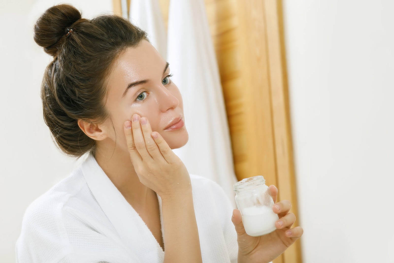 Woman looking at her skin in the mirror