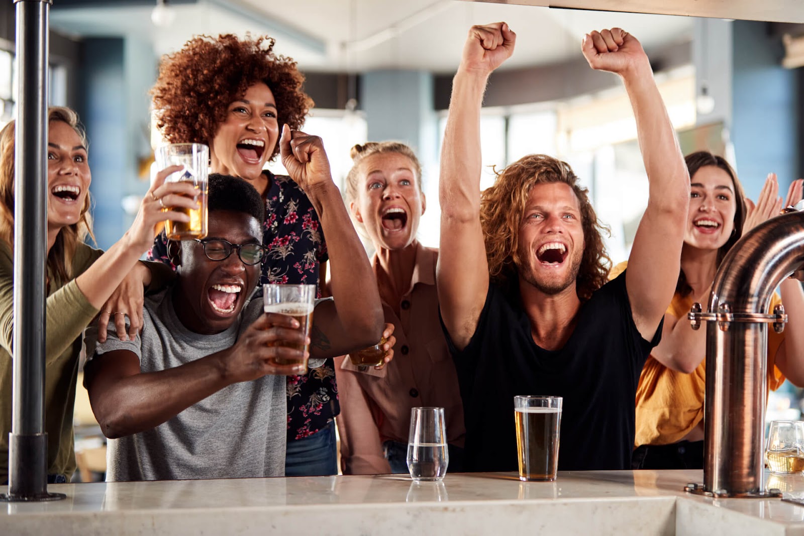 Group of people cheering at a spots bar