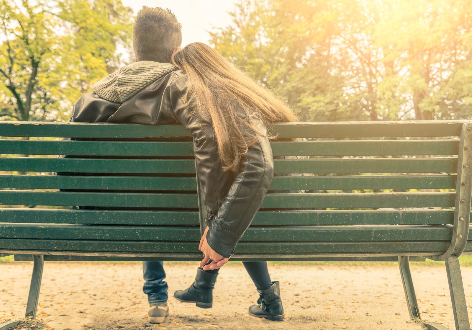 Woman and man cuddling on a park bench