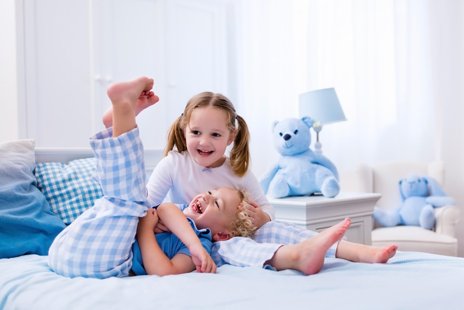 Children playing in bed in their jammies